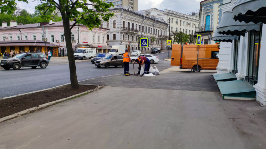 Рабочие укладывают асфальт рядом с рестораном в Казани