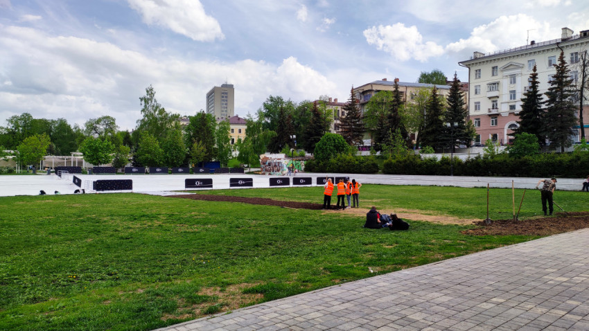 Рабочие укладывают газон в центре города