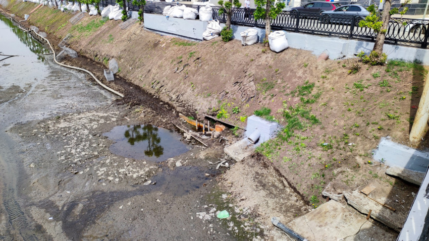 Стоковая труба и участок обмелевшего русла в городе