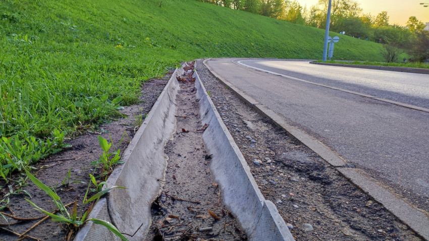 Ливнеприёмный жёлоб вдоль бордюра на повороте дороги
