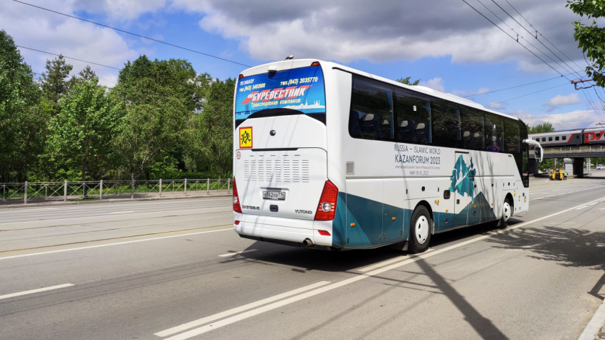 Автобус KazanForum 2023 движется по городской улице