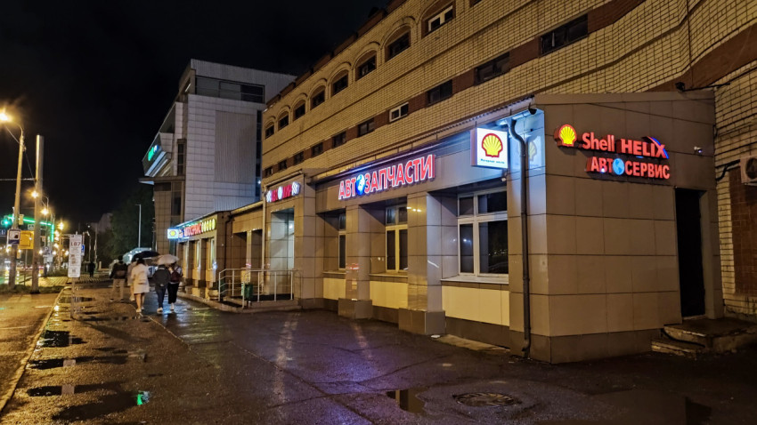 Фасад автосервиса и магазина автозапчастей ночью
