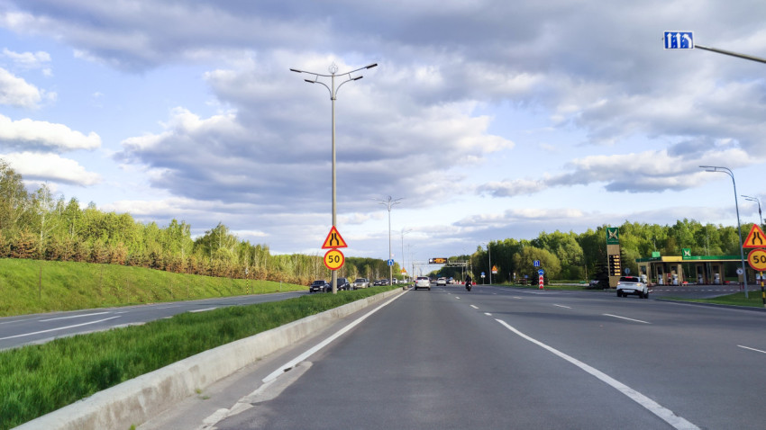 Разметка и дорожные знаки на шоссе среди леса