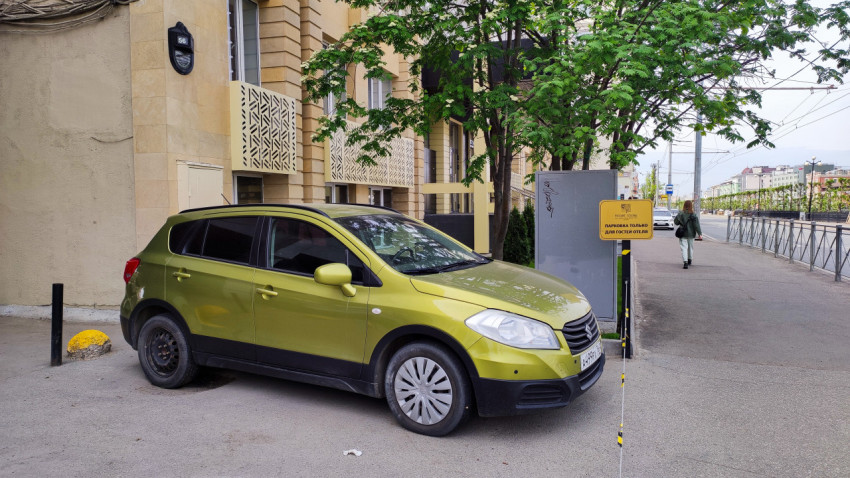 Автомобиль припаркован у отеля рядом с улицей