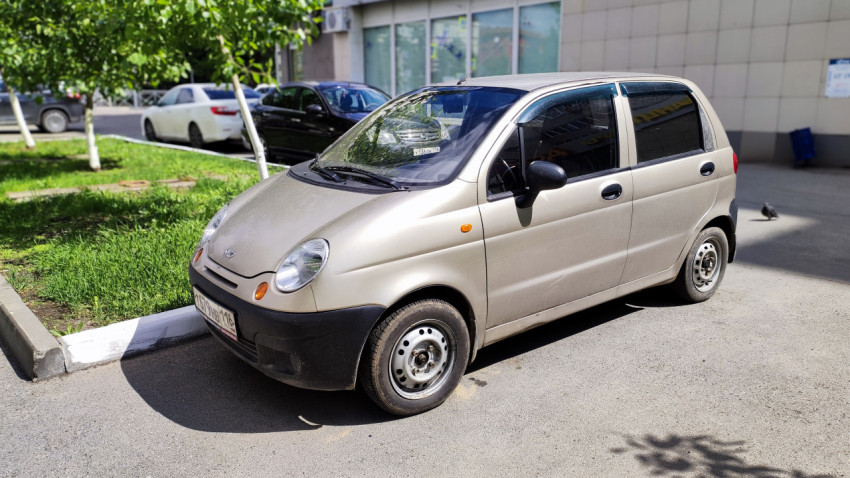 Старый автомобиль Daewoo Matiz на парковке у жилого дома