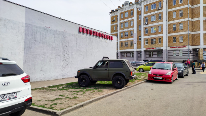 Автомобиль Нива на парковке у магазина автозапчастей