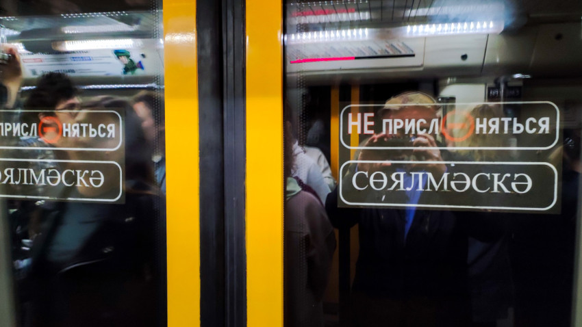 Надпись на двери вагона метро на двух языках