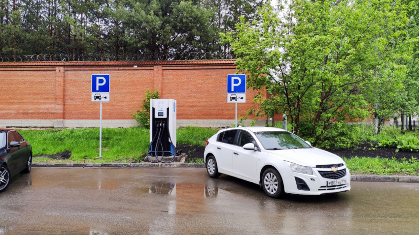 Электрозарядная станция на парковке возле кирпичной стены