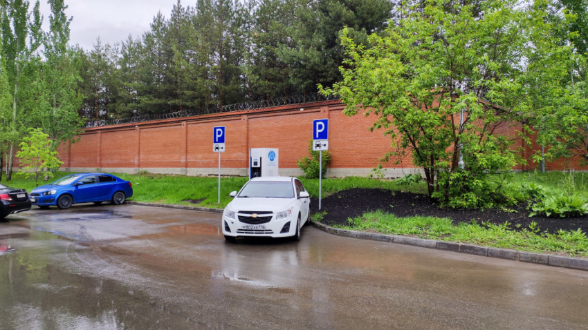 Парковка электромобилей у стены с колючей проволокой