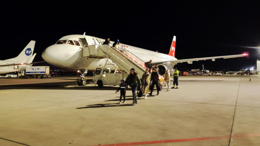 Люди спускаются по трапу из самолета Nordwind на ночной стоянке