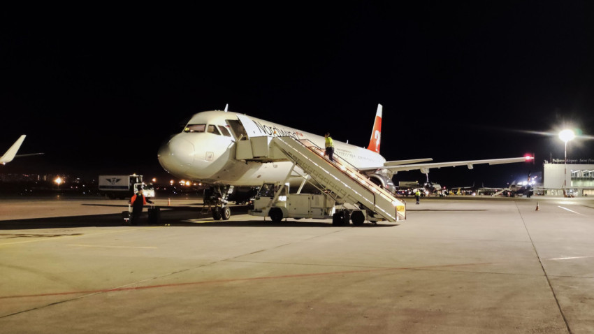 Самолет Nordwind ночью на фоне терминала аэропорта Пулково