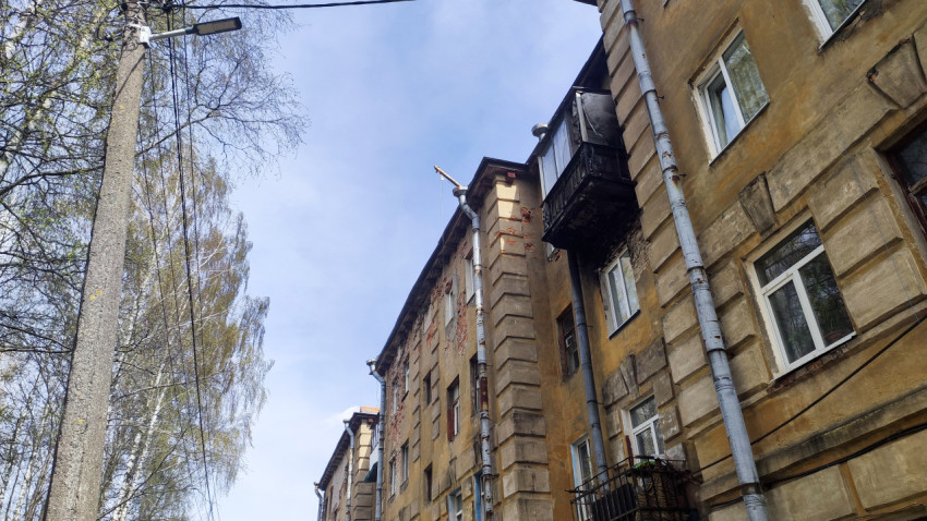 Старый жилой дом с повреждённым фасадом и балконом