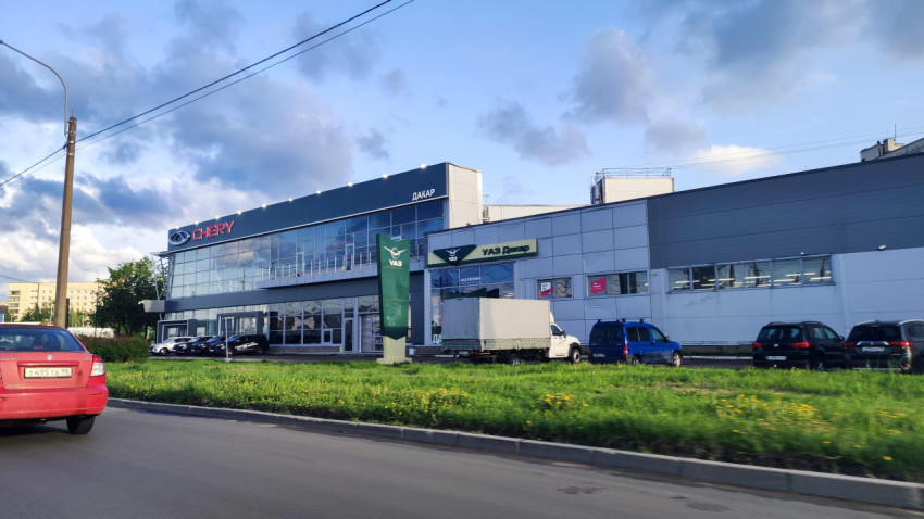 Автосалон CHERY и УАЗ с витринным фасадом и парковкой вдоль проезжей части