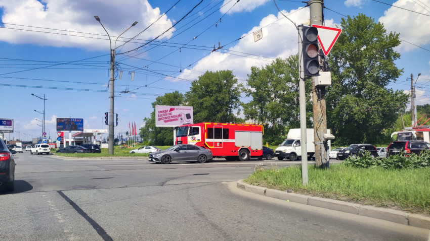 Пожарный автомобиль на городском перекрёстке среди плотного трафика