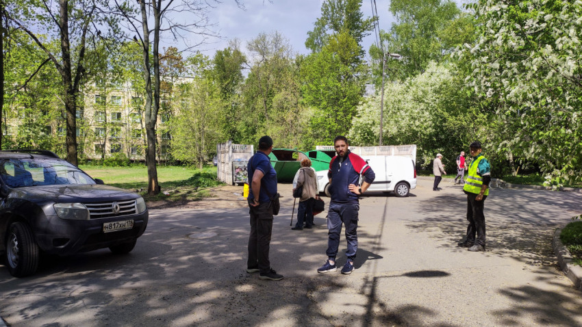 Группа людей и автомобили во дворе жилого района