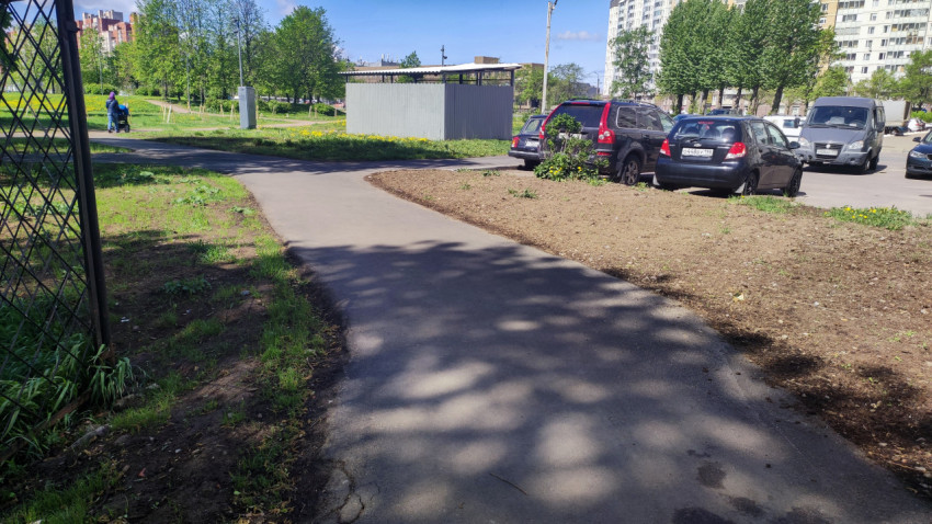 Асфальтированная дорожка вдоль парковки с автомобилями