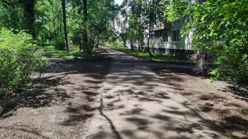 Асфальтовая дорожка вдоль жилого дома с зелёными насаждениями
