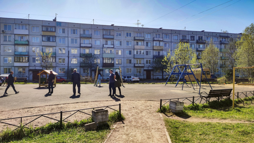 Двор с пятиэтажным домом и детской площадкой