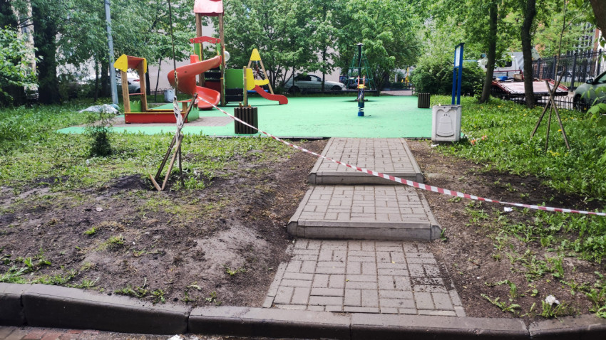 Детская площадка с ограждением во дворе жилого квартала