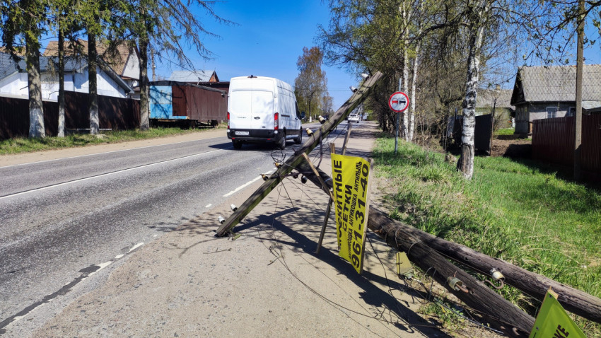 Упавший электрический столб с рекламным щитом на обочине