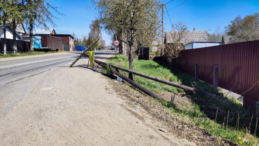 Упавший деревянный столб с проводами у загородной дороги