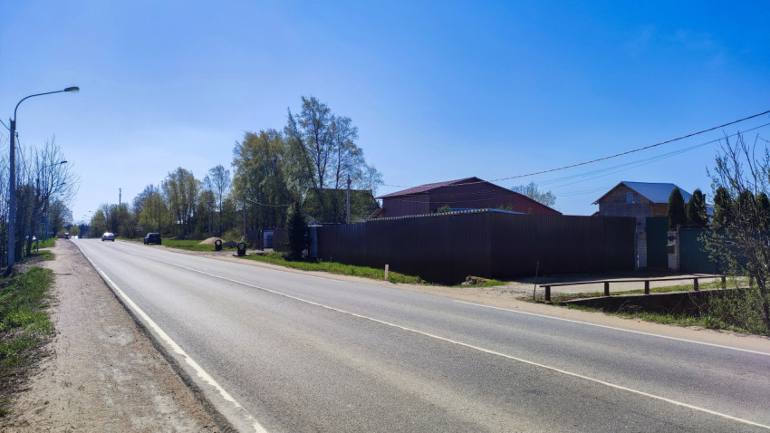 Загородная дорога с видом на автосервис за забором