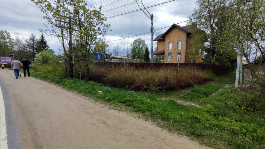 Жилой дом из кирпича за забором у дороги