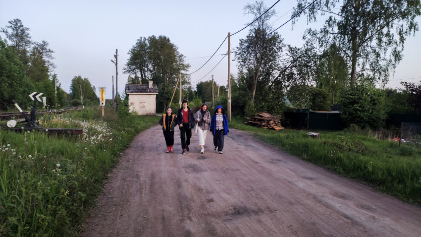 Группа людей на сельской дороге рядом с железнодорожным переездом
