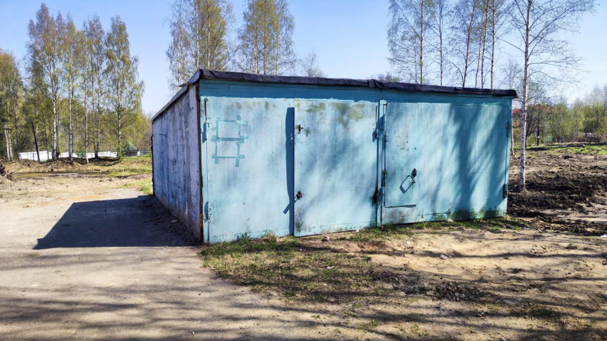 Металлический гараж с голубыми воротами