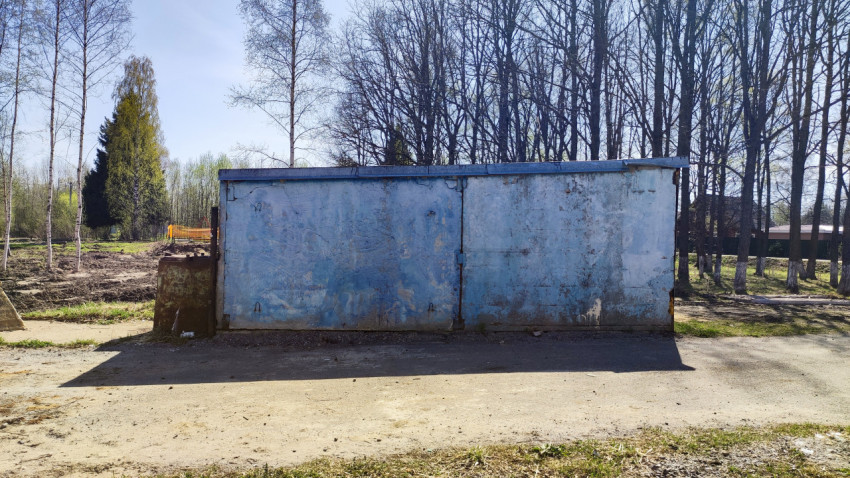 Старинный металлический гараж с выцветшими воротами