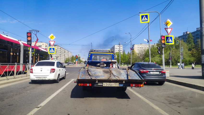 Городской перекрёсток с трамваем и автомобилями на красный свет