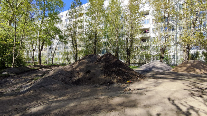 Кучи земли и щебня во дворе многоэтажного дома