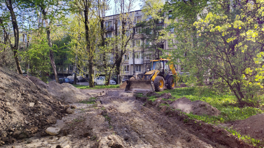 Экскаватор на земляных работах во дворе