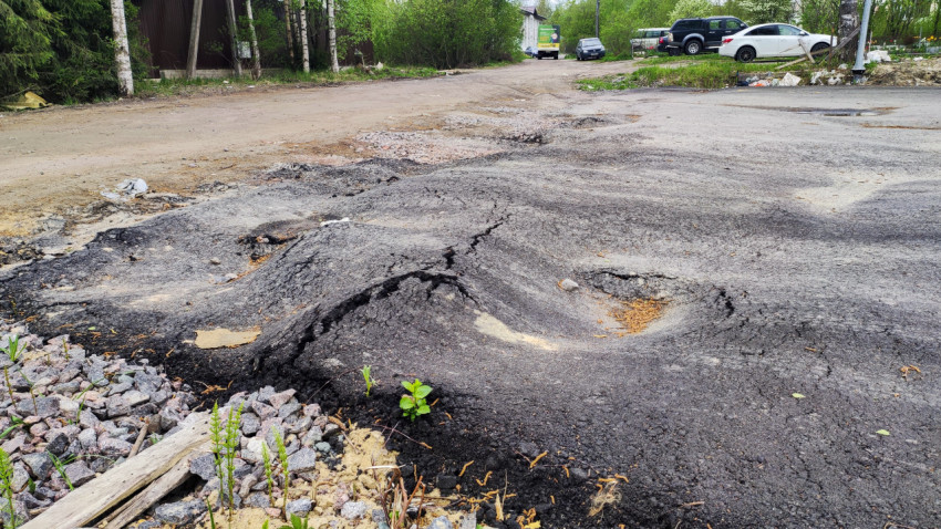 Повреждённый асфальт и каменистая поверхность во дворе
