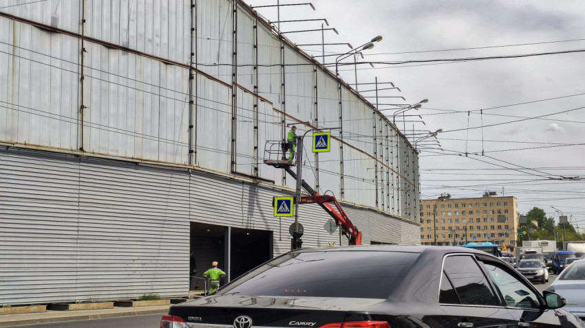 Рабочие на подъёмнике у металлического фасада здания