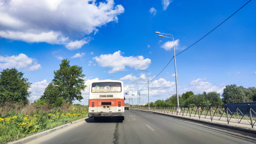 Пригородная дорога с городским автобусом и пешеходным ограждением