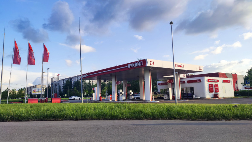 АЗС «Лукойл» с навесом, колонками и красными флагами у проезжей части