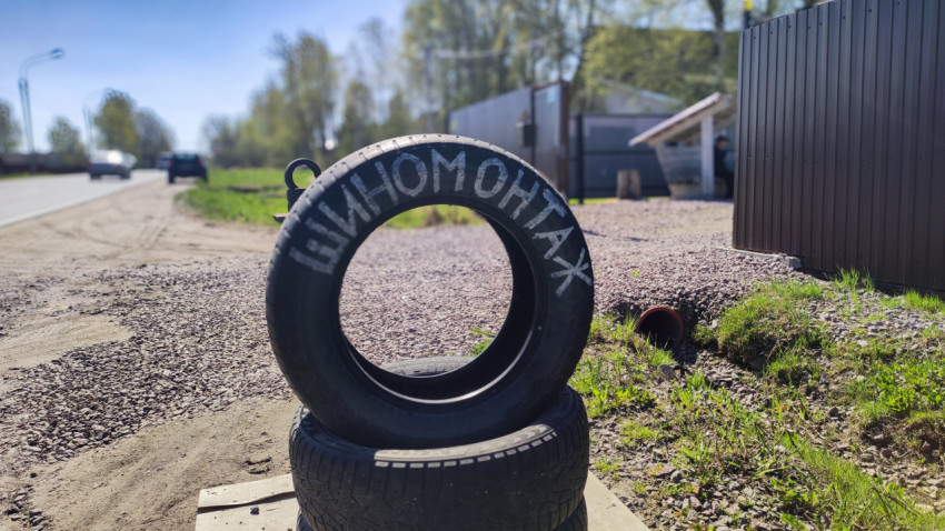 Шина с надписью «Шиномонтаж» у дороги