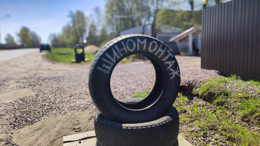 Покрышка с надписью «Шиномонтаж» на обочине дороги
