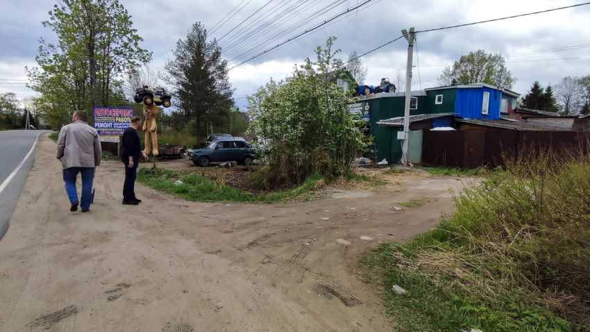 Автосервис у дороги с вывеской и старыми машинами