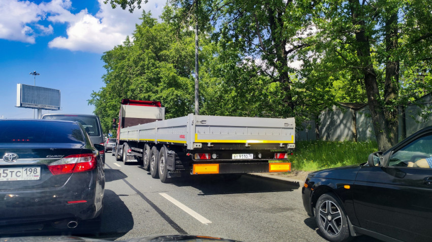 Полуприцеп-платформа в городском заторе на многополосной дороге