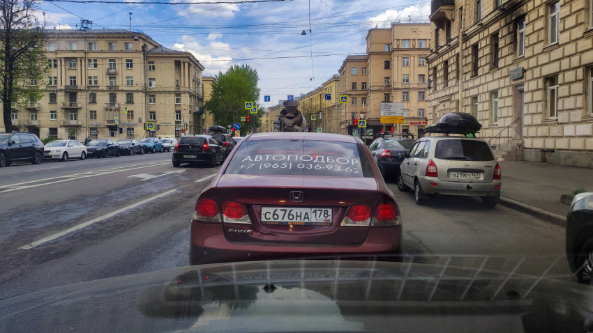 Автомобиль Honda Civic с рекламой услуги «Автоподбор» в городском потоке