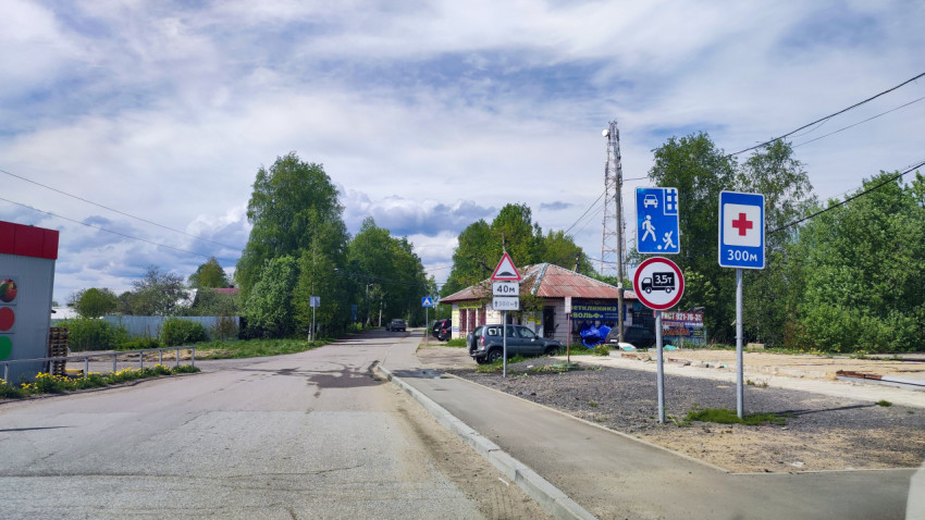 Загородная улица с дорожными знаками и зданиями