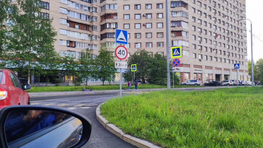 Группа дорожных знаков у жилого дома: ограничение 40, лежачий полицейский и пешеходный переход