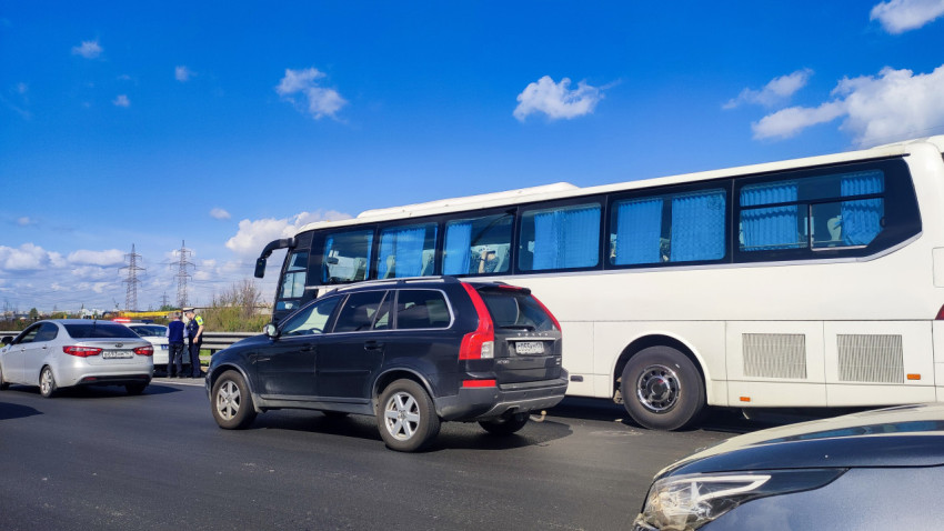 Автобус и кроссовер на многополосной дороге при наличии служебного авто у обочины