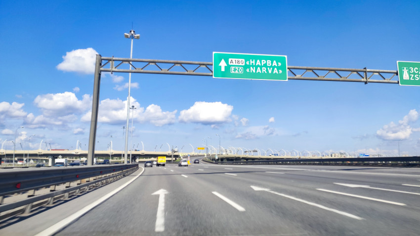 Указатель A180 «Нарва» E20 и табличка «ЗСД» над многополосной развязкой