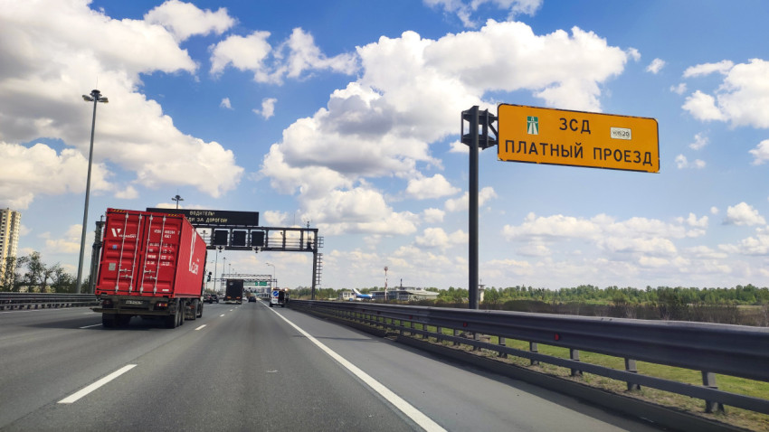 Дорога с портальными конструкциями и жёлтым щитом «ЗСД платный проезд»