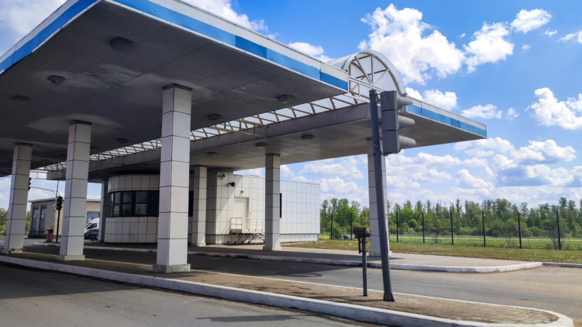 Въездной павильон с широким навесом и стеклянной будкой у ограждения