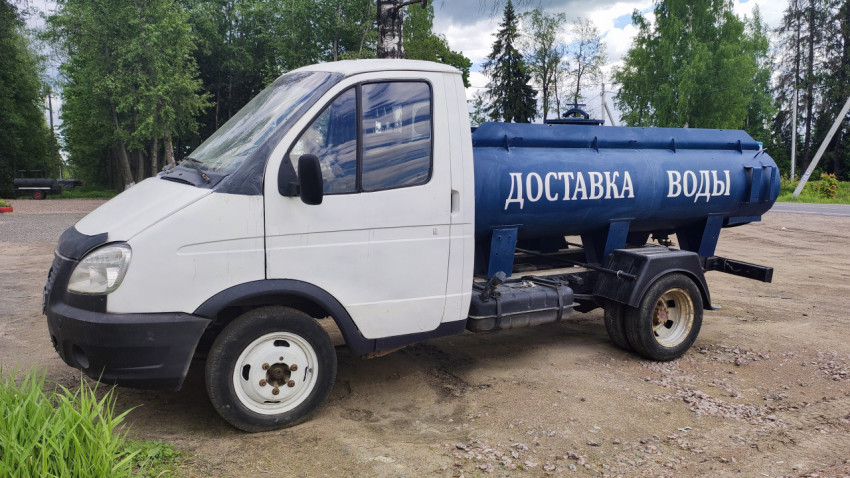 Автомобиль для доставки воды на грунтовой площадке