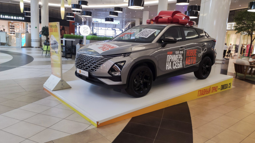 Автомобиль Omoda C5 на подиуме в торговом центре